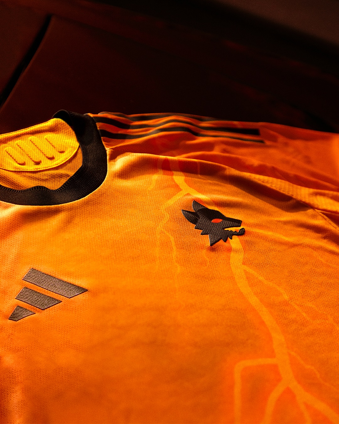 Maglia away dell'AS Roma 2025-2026: arancione con i fulmini di Marte